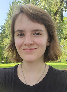 Profile of Advanced Graduate Trainee, Megan Baur posed in grassy outdoor setting.