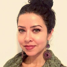 Close up photo of Africana Studies faculty member, Tiffany Montoya posing against a yellow-tinted wall.