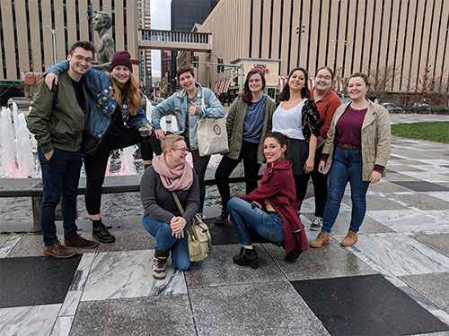 Group of students standing in front of statue