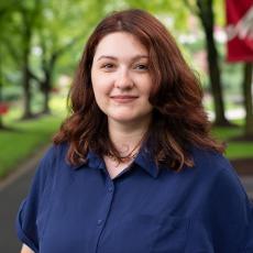 Admissions counselor standing on campus for portrait.