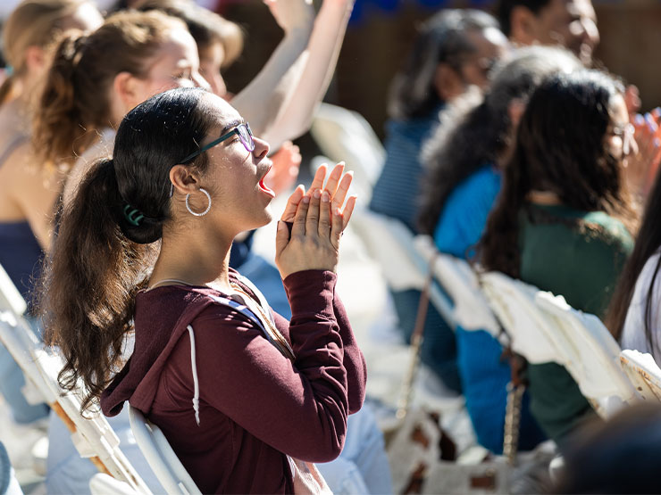 College students clap and cheer outdoors.