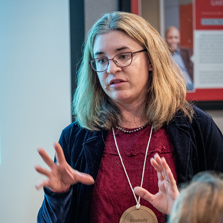 Faculty member Kim Heimen lecturing in front of group of individuals.