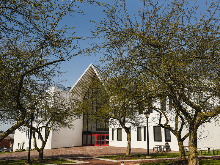 The Baker Center for the Arts framed by blossoming trees on a spring day.