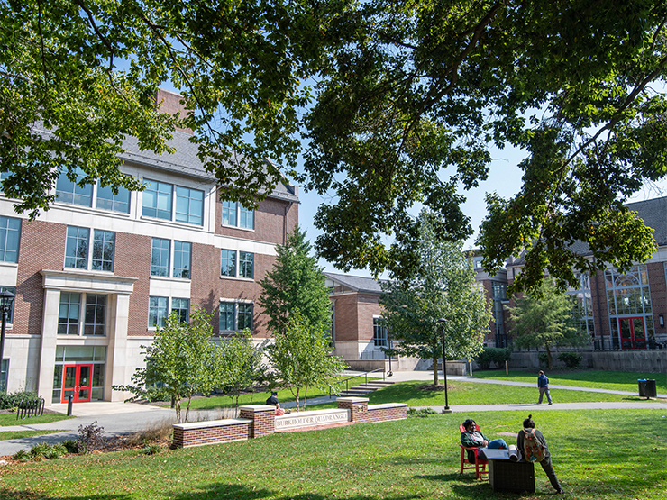 Seated students converse on Burkholder Quad on Muhlenberg College campus.