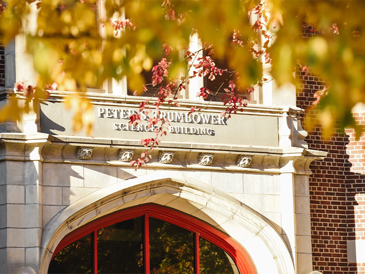 Trumbower Hall is framed by bright fall leaves on the campus of Muhlenberg College.