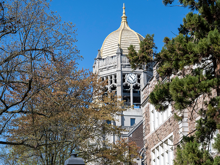 The clocktower of Haas College Center stands against a bright blue spring sky.