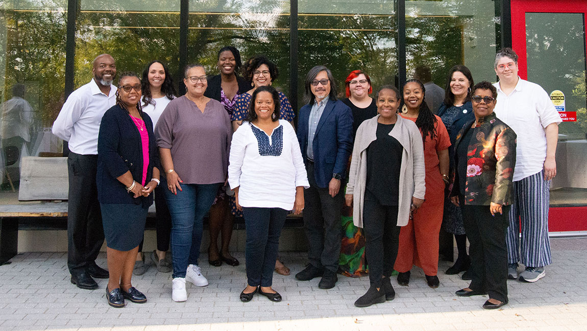 A group of diversity officers from various institutions poses for a group photo