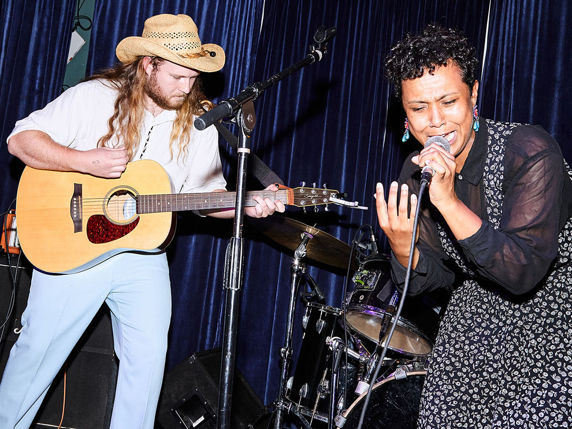 Two young people perform music on stage