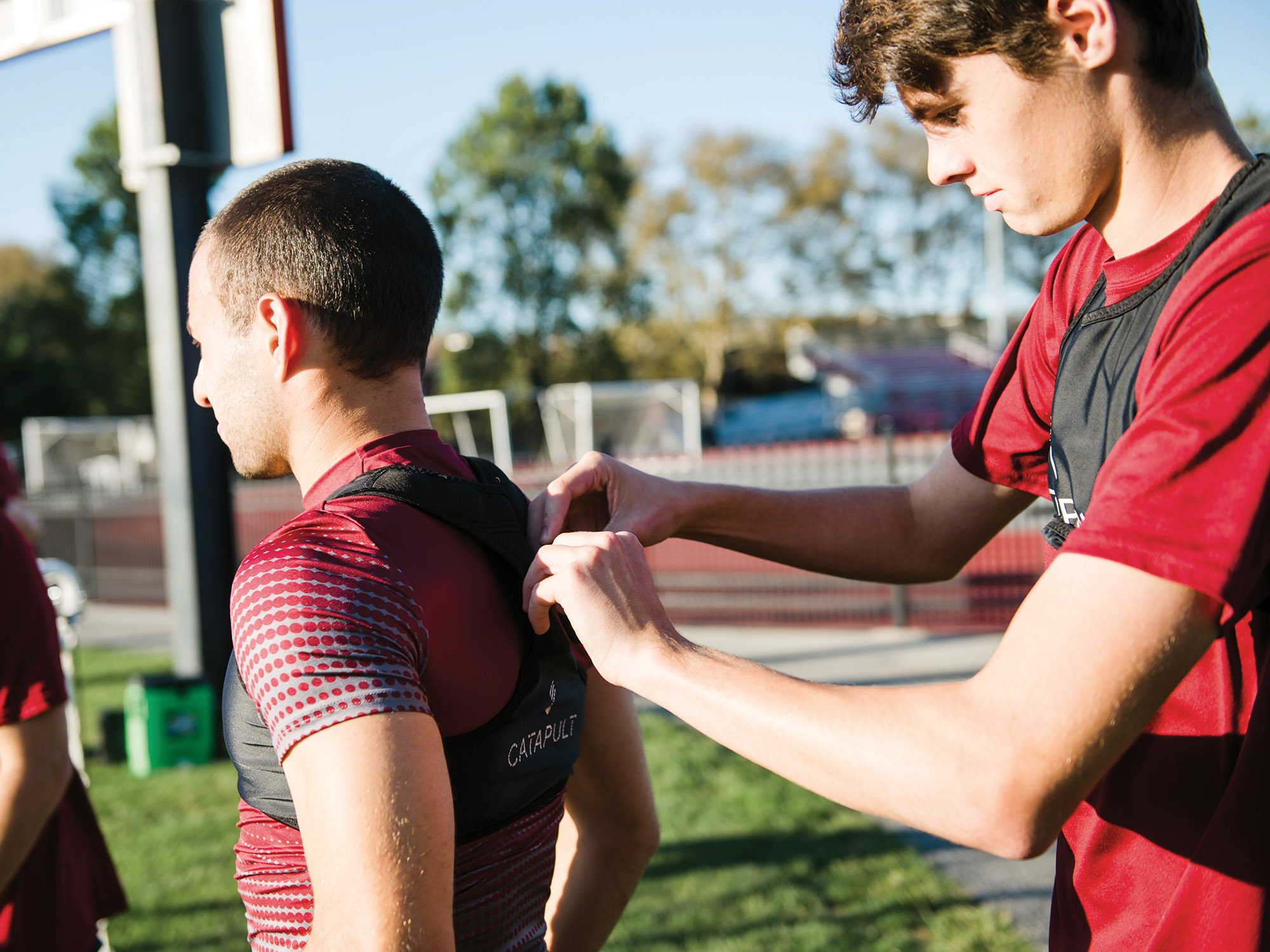 Image for Greyson King ’23 helps Jordan Cimring ’20 into his vest.